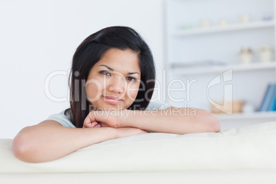 Smiling woman crossing her arms on a white sofa