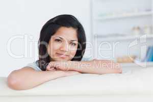 Smiling woman crossing her arms on a white sofa