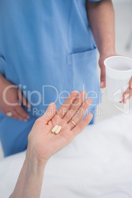 Nurse giving plastic glass to a patient
