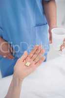 Nurse giving plastic glass to a patient