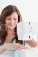Woman using a sewing machine while smiling