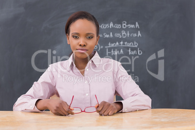 Serious teacher holding her glasses