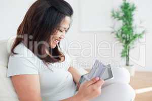 Woman on a couch while holding a tactile tablet and a card