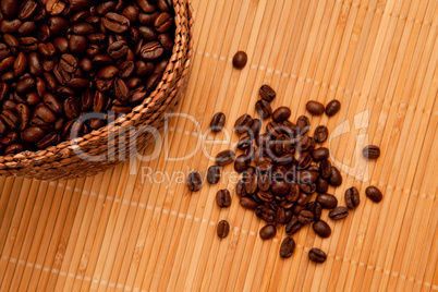 Seeds in front of a basket full of coffee seeds