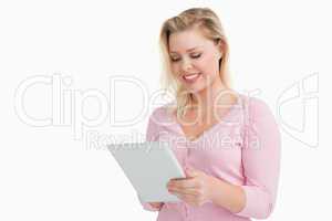 Blonde woman standing while using her touchscreen