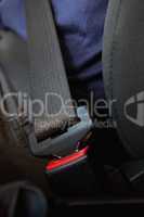 Person being seated with fastened seatbelt