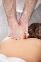 Doctor massaging the back of his patient while using the back of