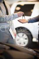 Salesman handing keys to a customer
