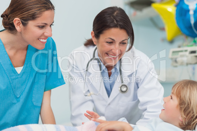 Nurse and doctor smiling to a child