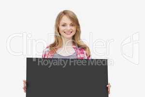 Woman looking at camera while holding a black board