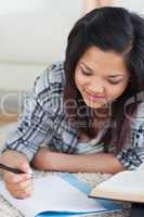 Woman lying on the floor looking at a notebook