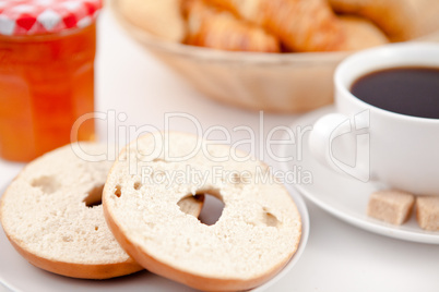 Doughnut cut in half and a cup of coffee on white plates with su