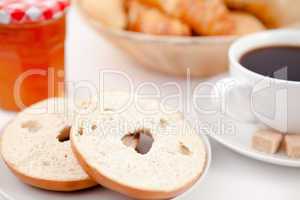 Doughnut cut in half and a cup of coffee on white plates with su