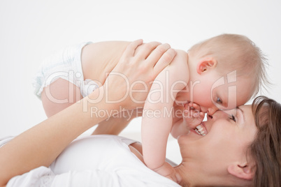 Happy mother holding her daughter while lying