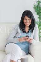 Woman relaxing on a couch while holding a phone