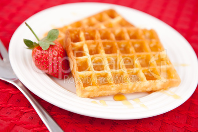 Waffles and strawberry together in a white plate