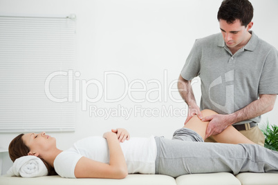 Physiotherapist massaging the leg of a woman while standing