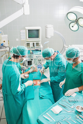 Group of surgeon operating an unconscious patient in an operatin