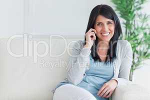 Woman talking on the phone while resting on a sofa