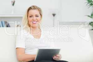 Casual woman sitting on a sofa using an ebook