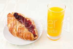Croissant next to a glass of orange juice