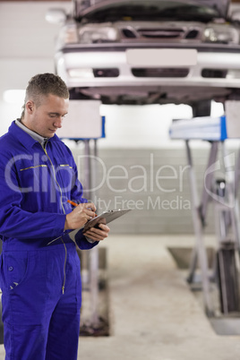 Concentrated mechanic holding a clipboard