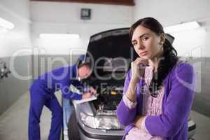 Thoughtful woman next to a mechanic