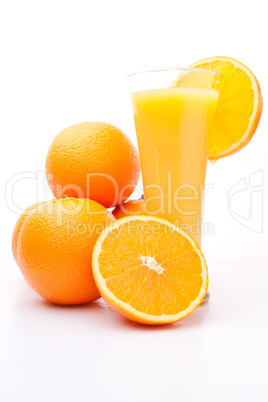 Heap of oranges near a glass of orange juice