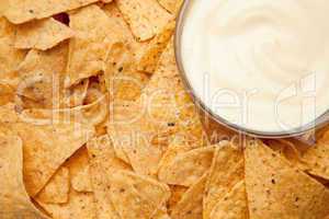 Nachos surrounding a bowl of white dip