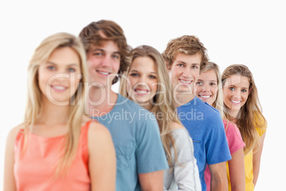 A smiling group standing behind each other at an angle