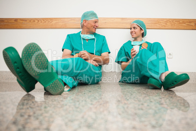 Surgeons talking while sitting in the floor