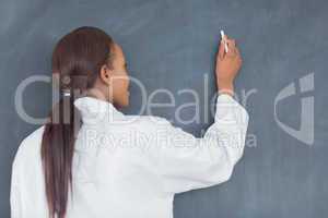 Teacher smiling while writing on a blackboard