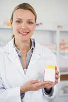 Smiling pharmacist presenting a drug box