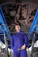 Mechanic standing up below a car