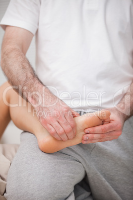 Reflexologist manipulating the sole of the patient