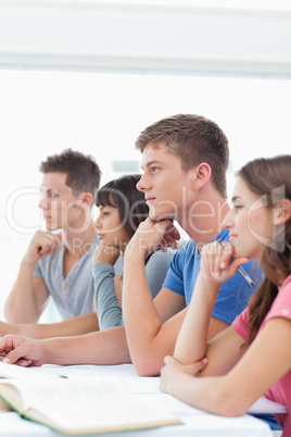 A group of students sitting in class listening
