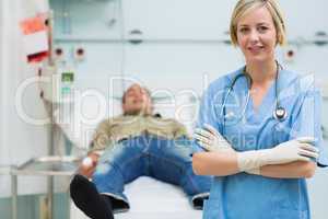 Nurse next to a male patient with arms crossed