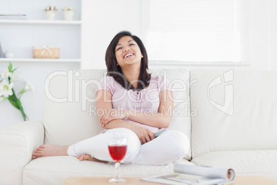 Woman laughing while resting on a sofa