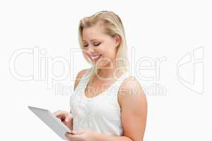 Smiling blonde woman using her tablet computer