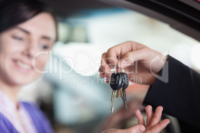 Woman in a car receiving keys