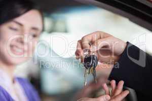 Woman in a car receiving keys