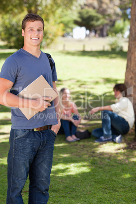 Student smiling while holding a textbook