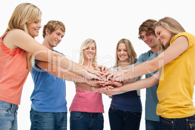 Low angle shot of friends smiling and looking at their hands sta