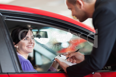 Woman in a car talking with a salesman