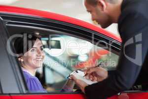 Woman in a car talking with a salesman