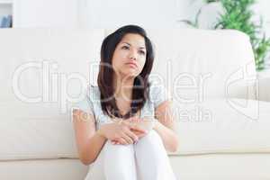 Woman is sitting in front of a couch