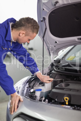 Concentrated mechanic looking at an engine