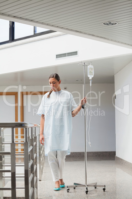 Female patient walking while holding a drip stand