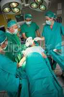 Surgeon working on the arm of a patient with a team of surgeons