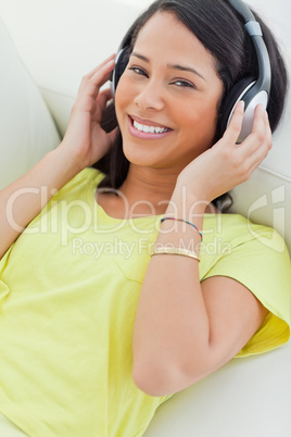 Portrait of a smiling Latino listening music on a smartphone